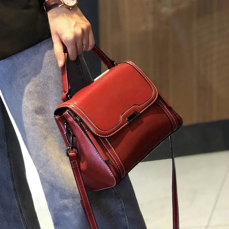 Women's brown genuine oil wax leather messenger bag with double strap and external pocket.