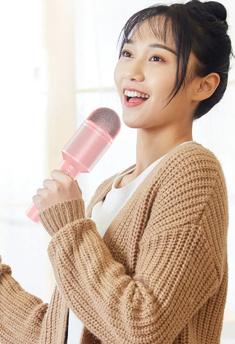 Wireless Bluetooth karaoke microphone in girly pink colour with integrated speaker grill and USB port.