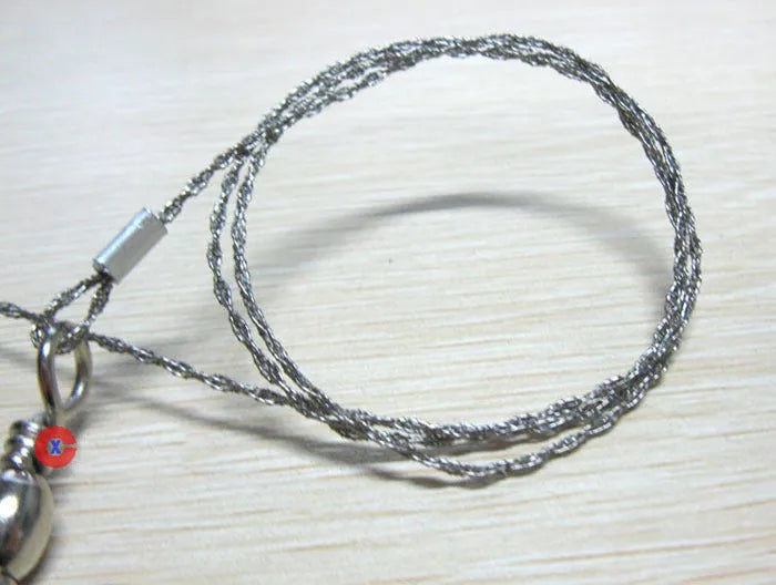 55cm stainless steel survival wire saw with pull rings and hoops on a green background.