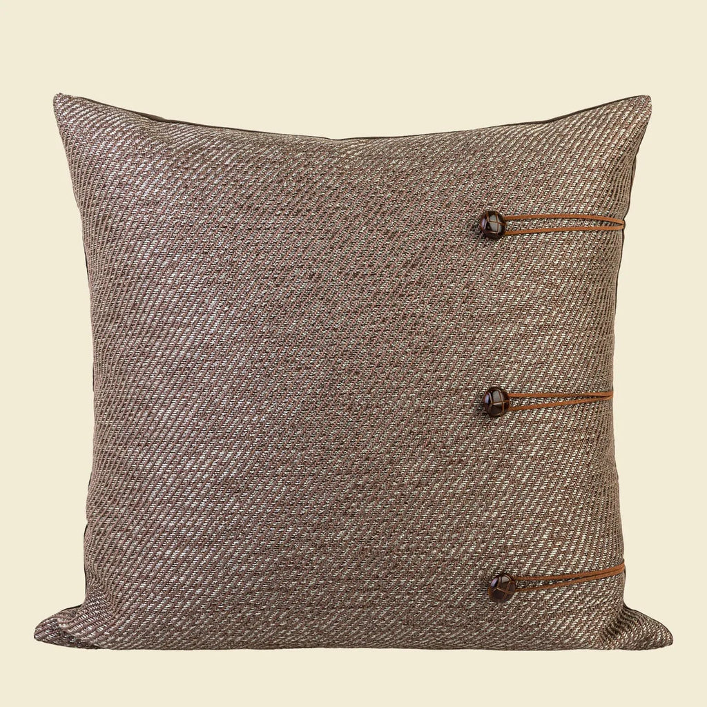 Square Chinese ancient style decorative cushion with a geometric pattern in a brown Maillard colour on a grey sofa.