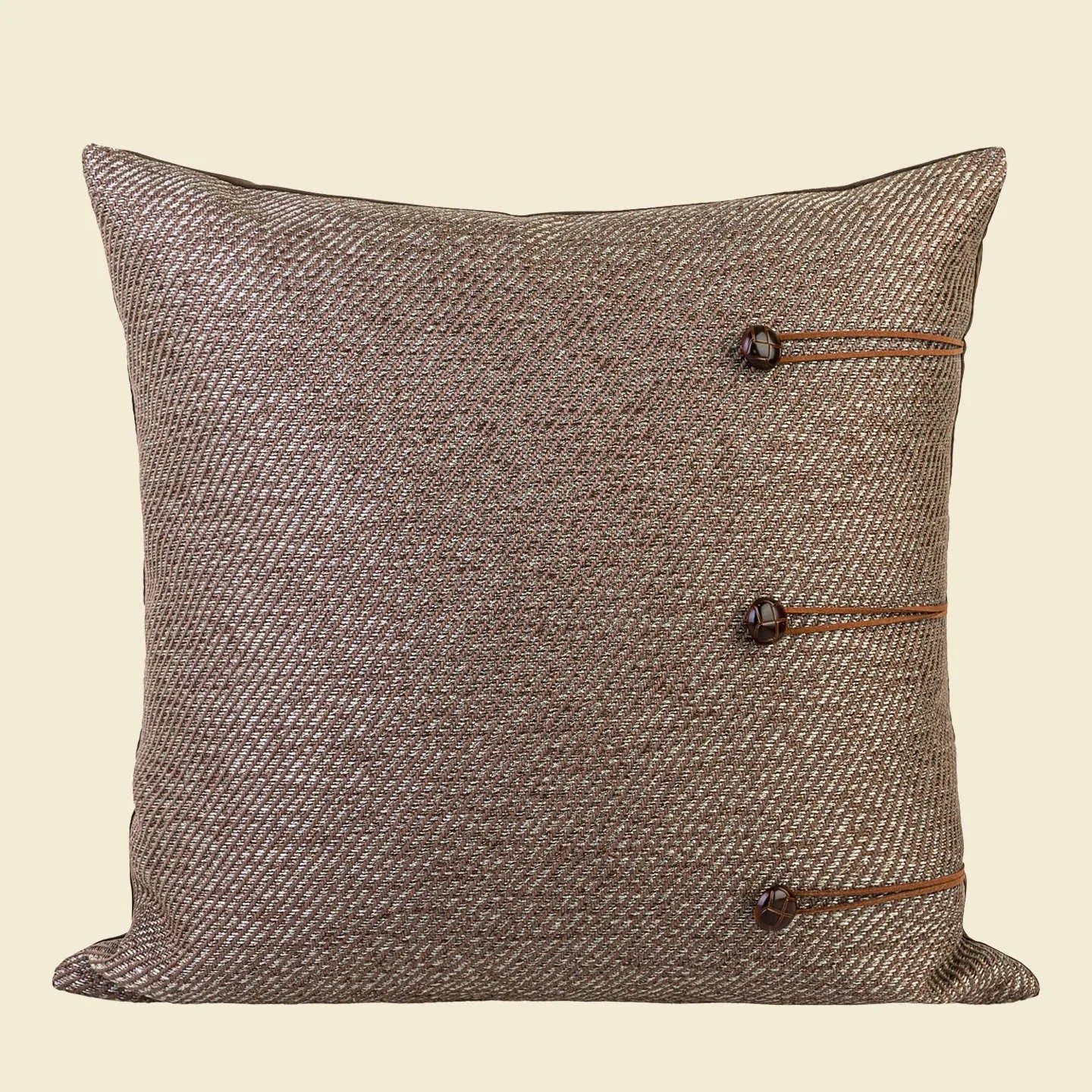 Square Chinese ancient style decorative cushion with a geometric pattern in a brown Maillard colour on a grey sofa.