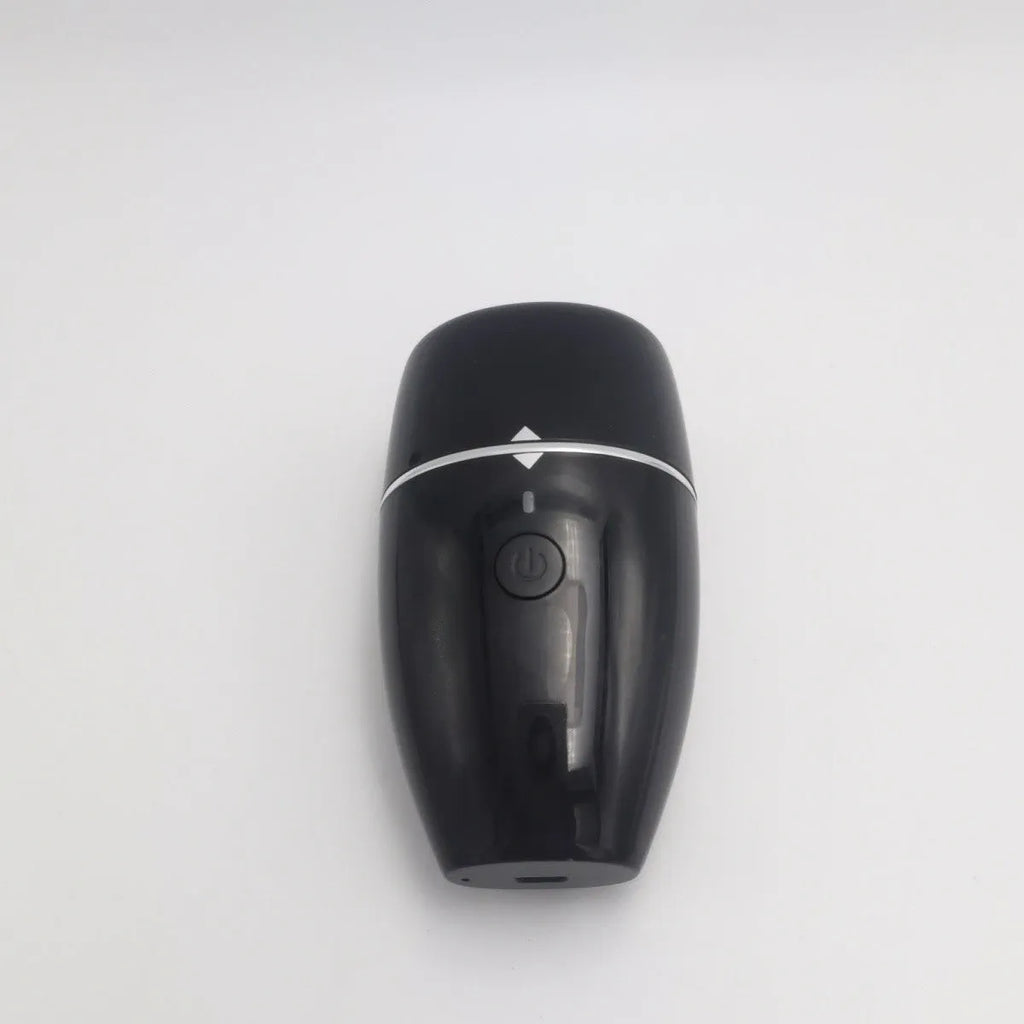 Black electric lip plumper device with a silicone tip next to a white USB charging cable.