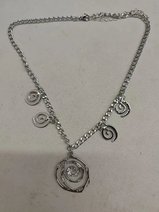 Spiral donut design necklace, bracelet, and ear hook set in gold or silver plating on a dark background.