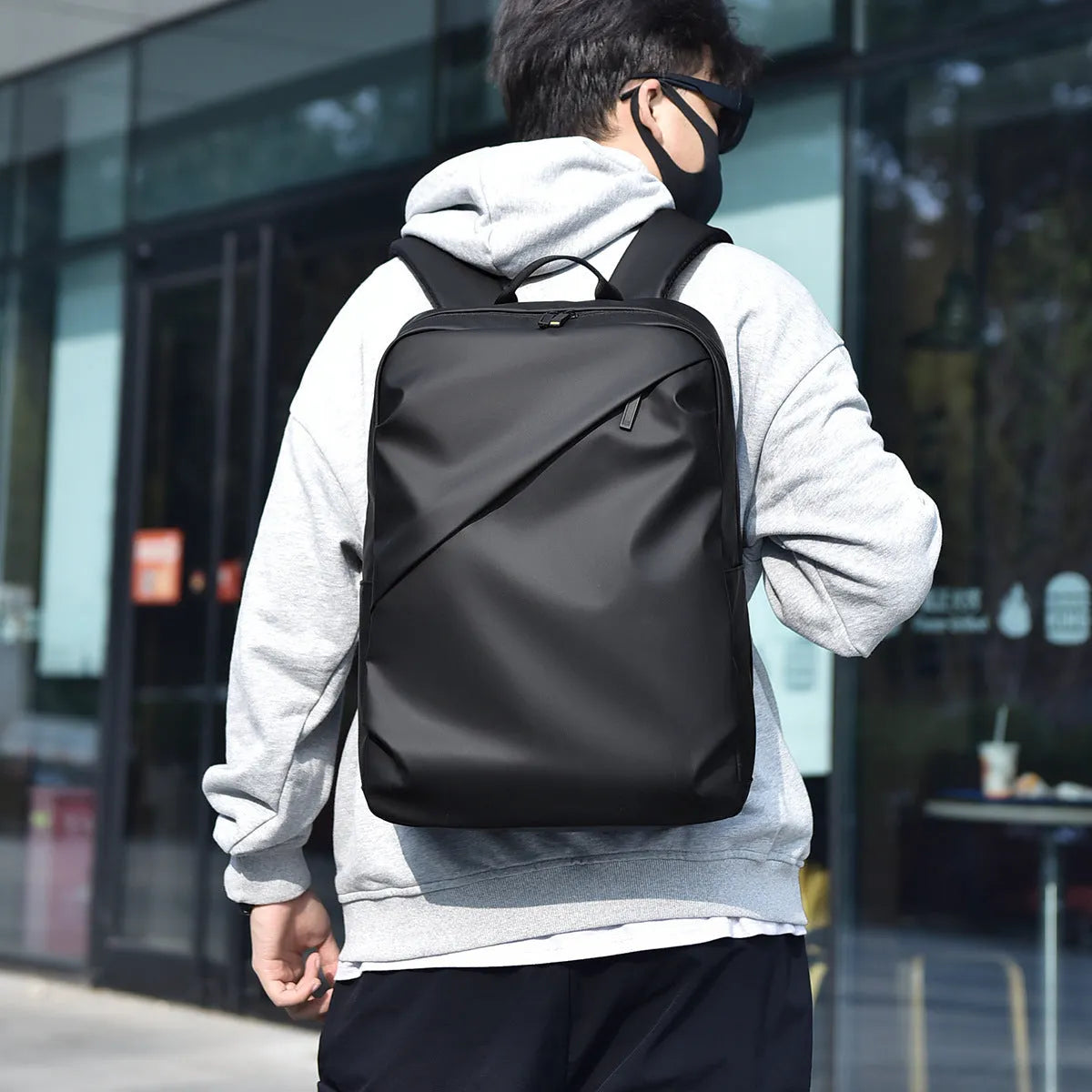 Waterproof PU leather backpack in black, blue or grey showing simple design and sewing thread detailing