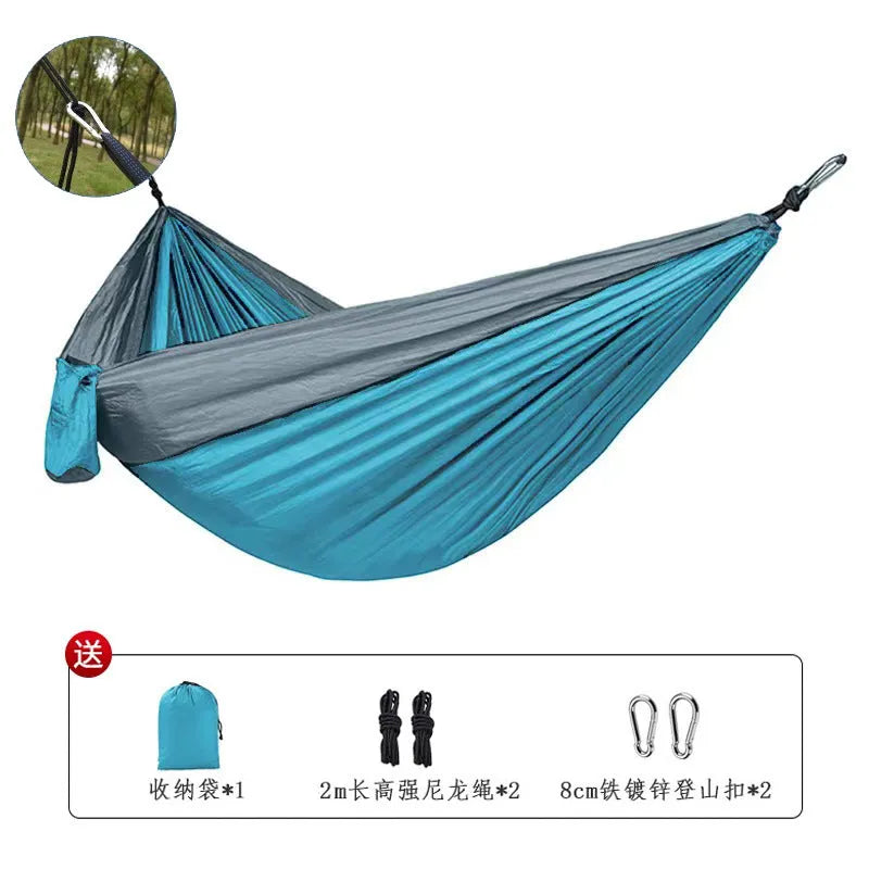 Blue nylon parachute cloth outdoor hammock with reinforced stitching hung between trees