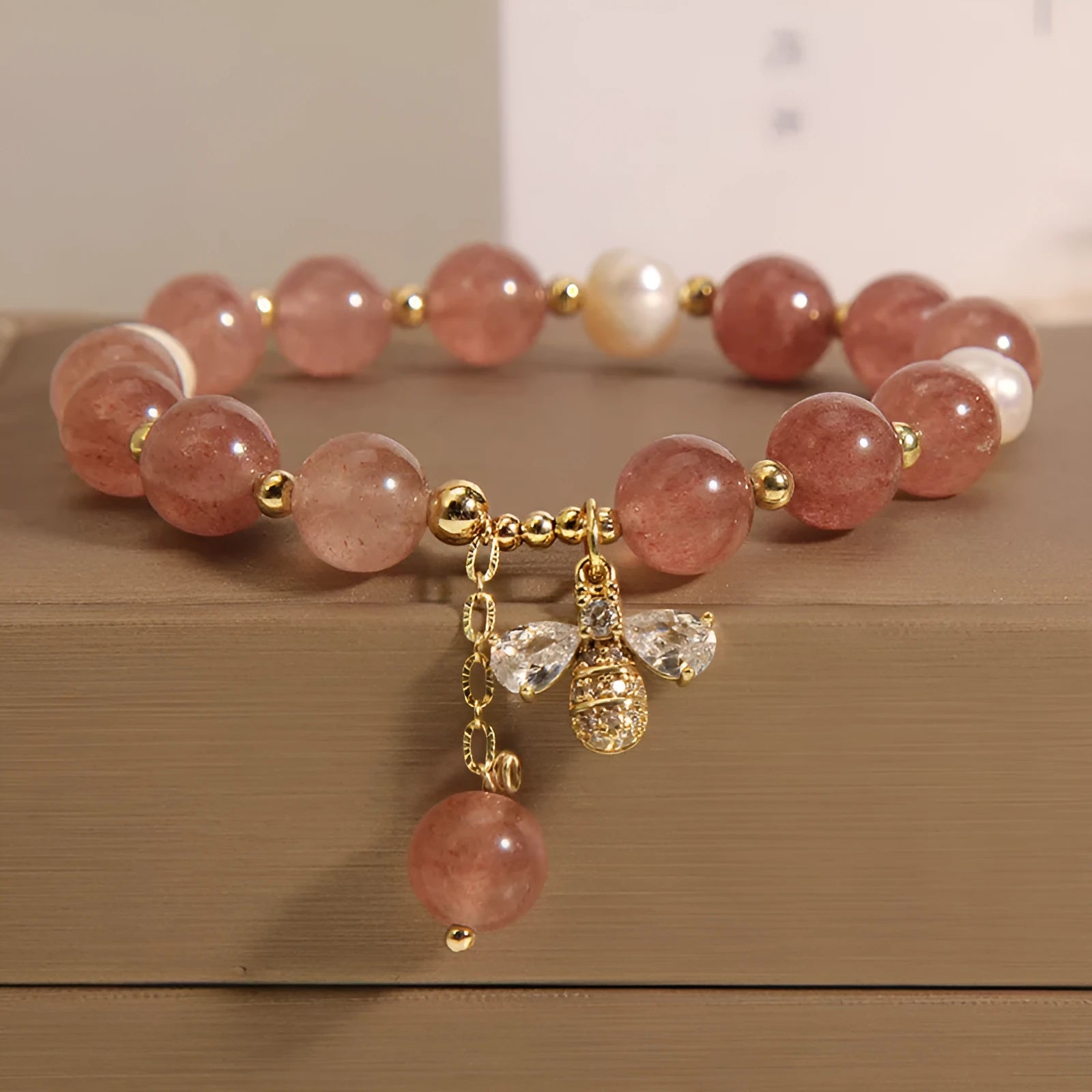 Strawberry quartz and freshwater pearl bracelet with zircon accents on woman's wrist