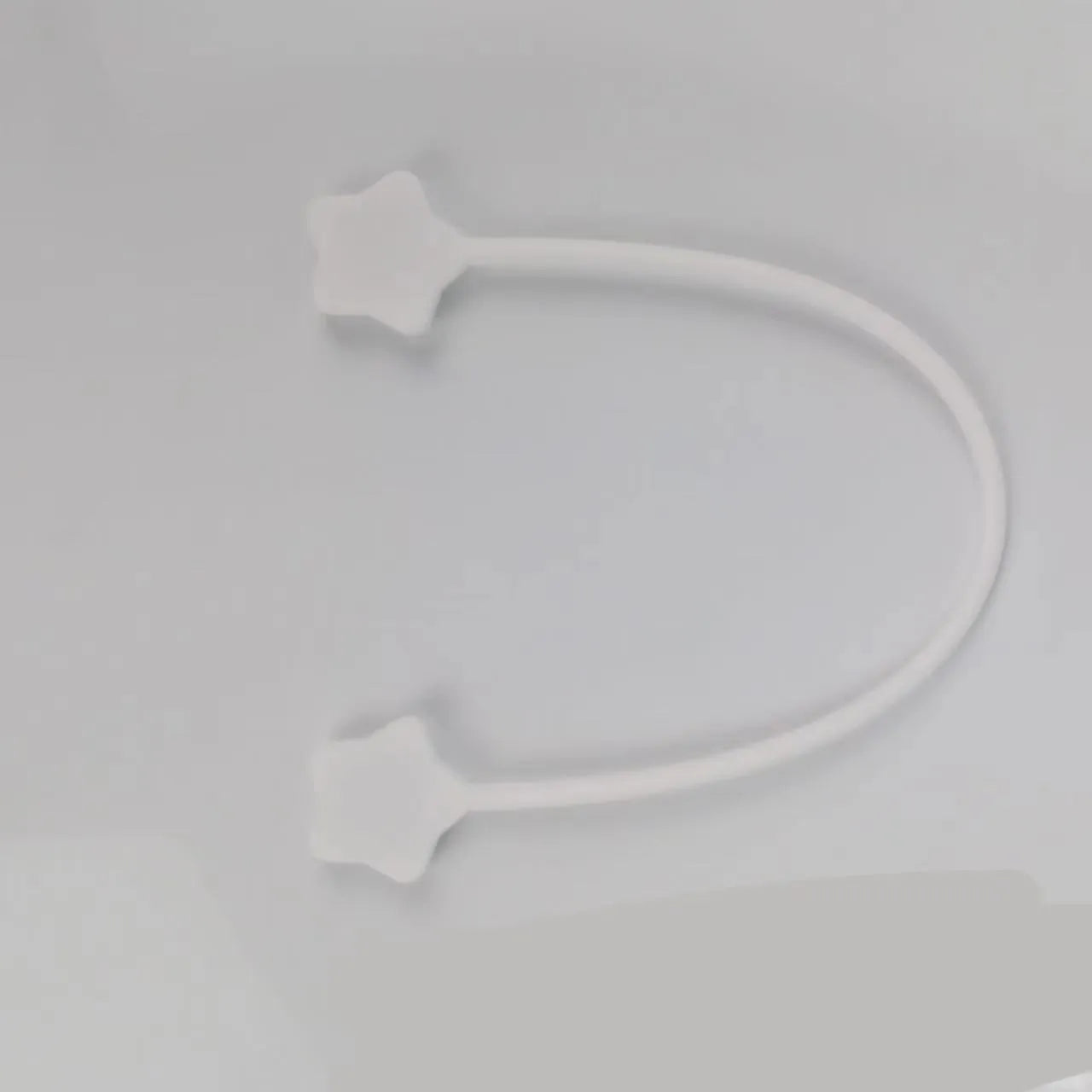Silicone wire winder with magnet for organising cables in assorted colours on a white background.