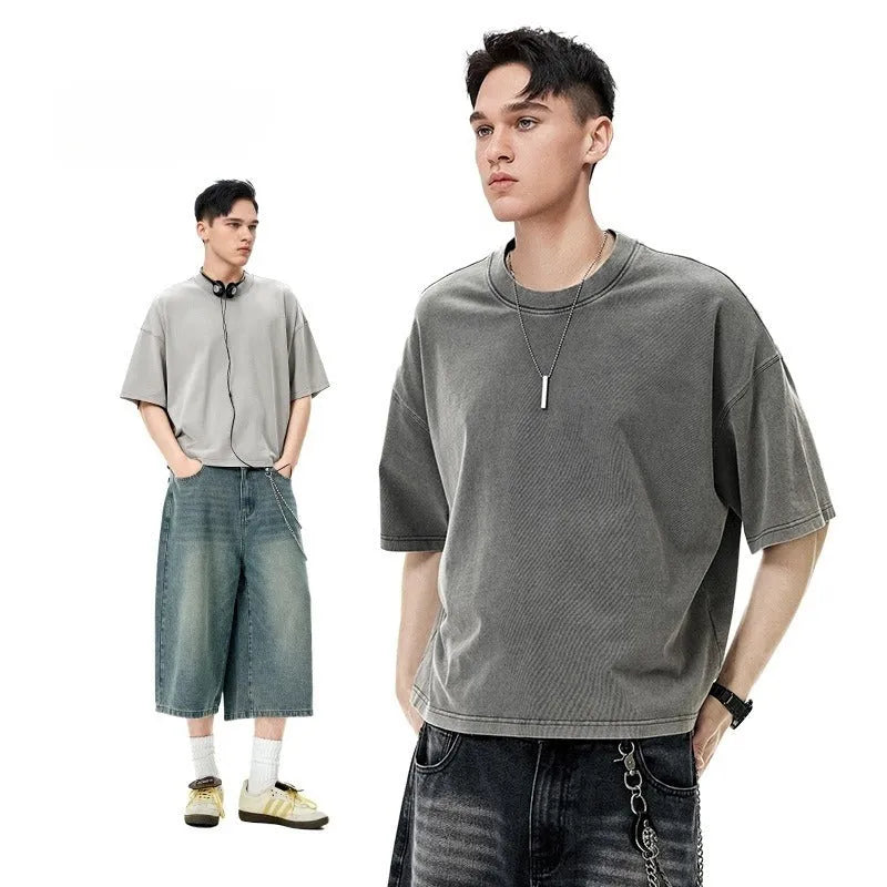 Man wearing a vintage washed khaki cotton t-shirt with loose fit and drop-shoulder sleeves.