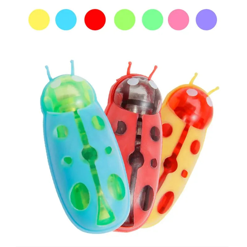 Small red ladybird shaped electric bug toy for cats on a wooden floor.