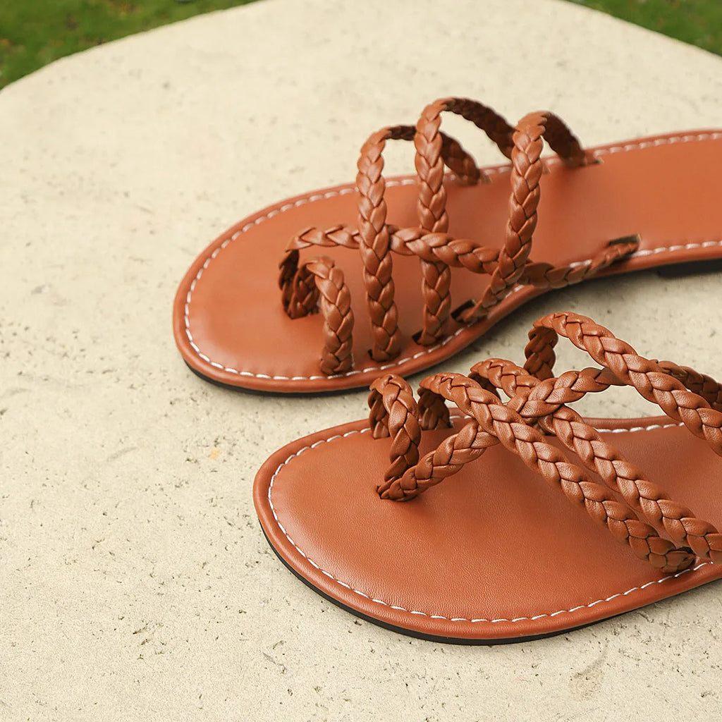 Women's woven artificial PU clip-toe Roman sandals with a flat rubber sole, shown in black.