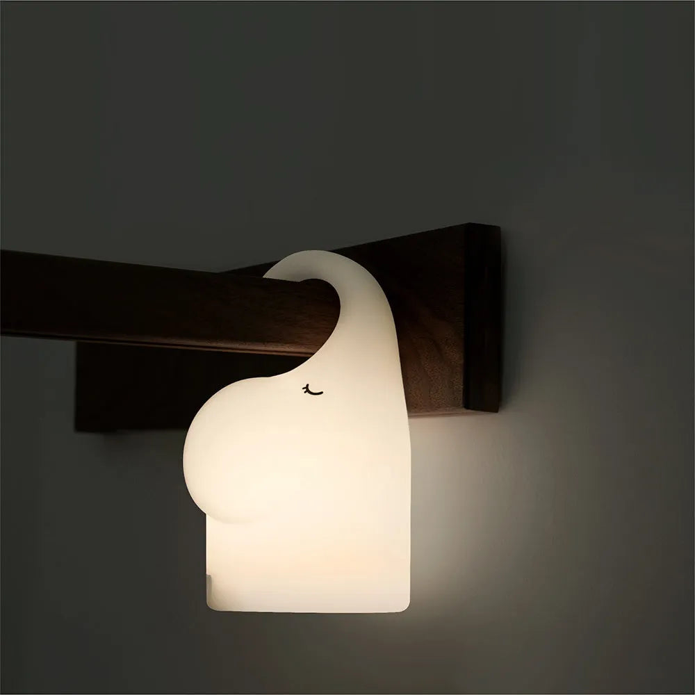 DOMI Elephant style LED night light with warm white glow on a bedside table.