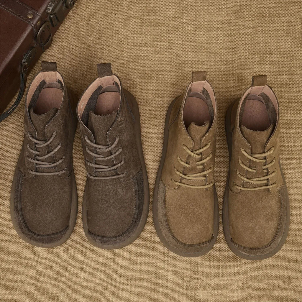 Grey genuine leather martin boots with wedge heel and front lace-up fastening on a neutral background