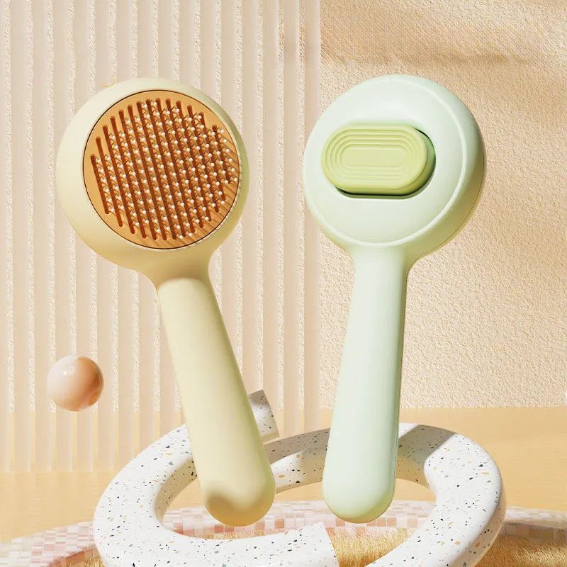 Green and yellow plastic cat brush with stainless steel teeth and a non-slip handle.