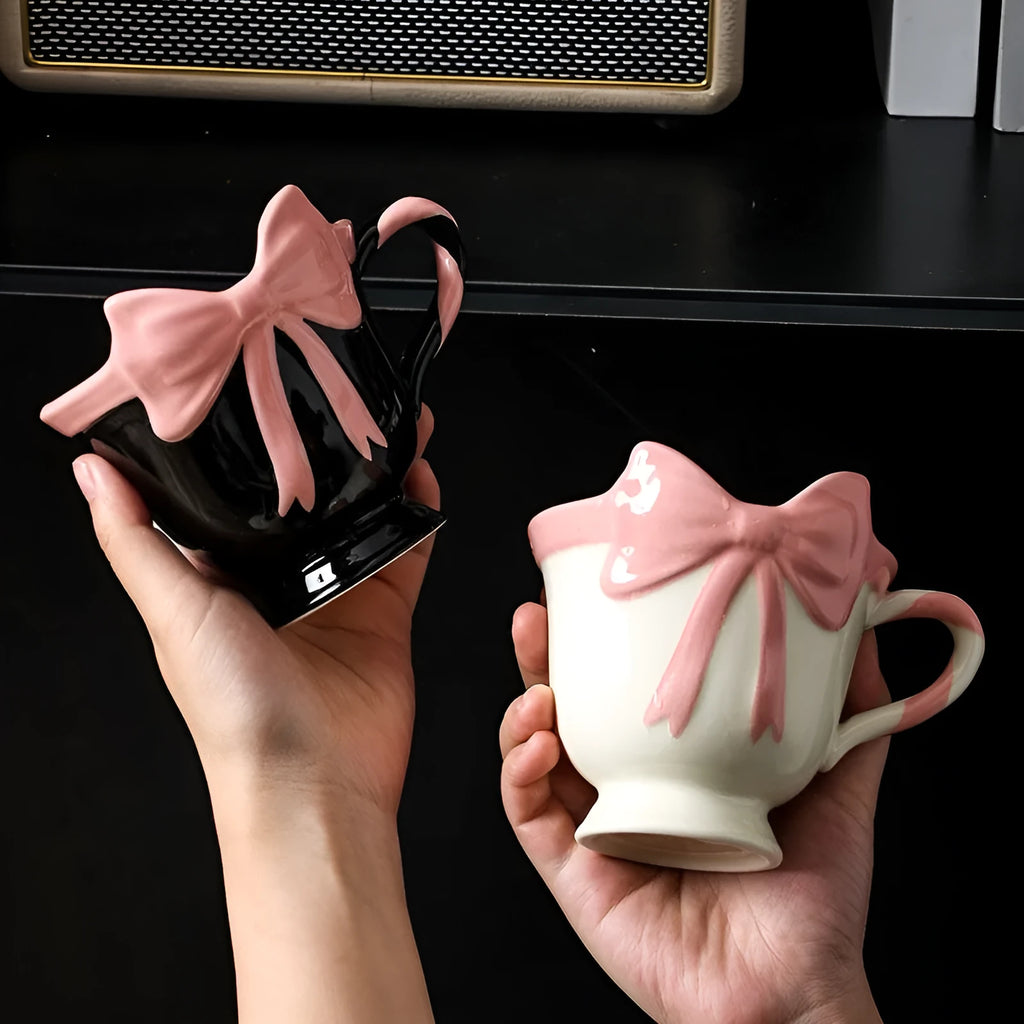 Ceramic mug with a pink and white girl's heart bow decoration on the side.