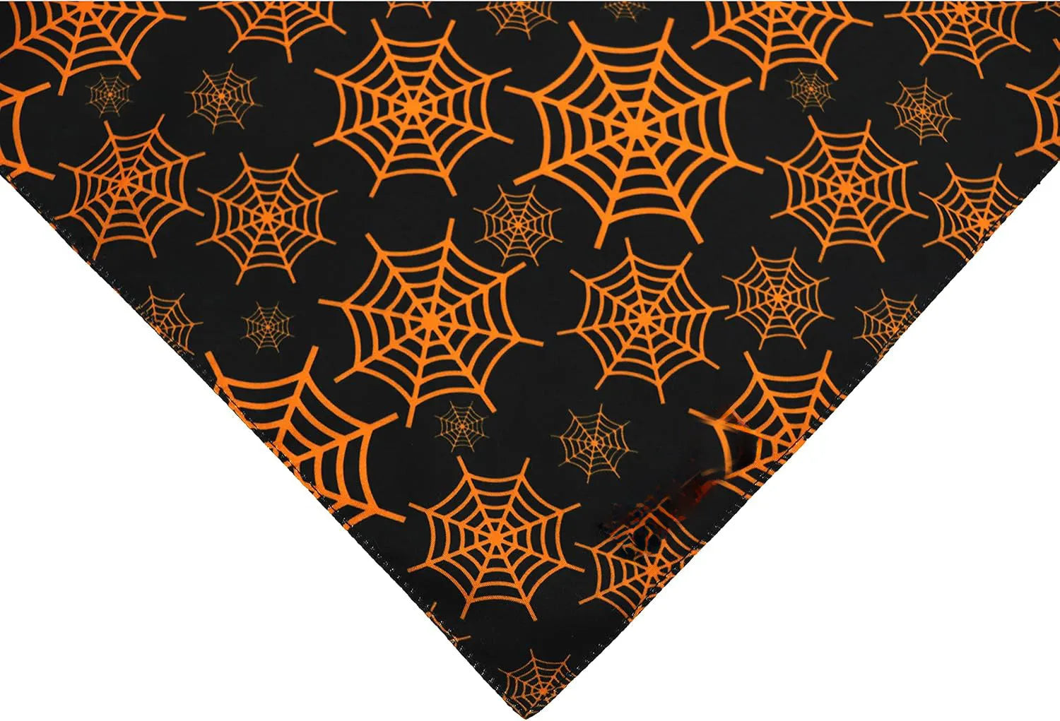 Black and orange reversible Halloween dog bandana with pumpkin and spider web patterns showing adjustable closure