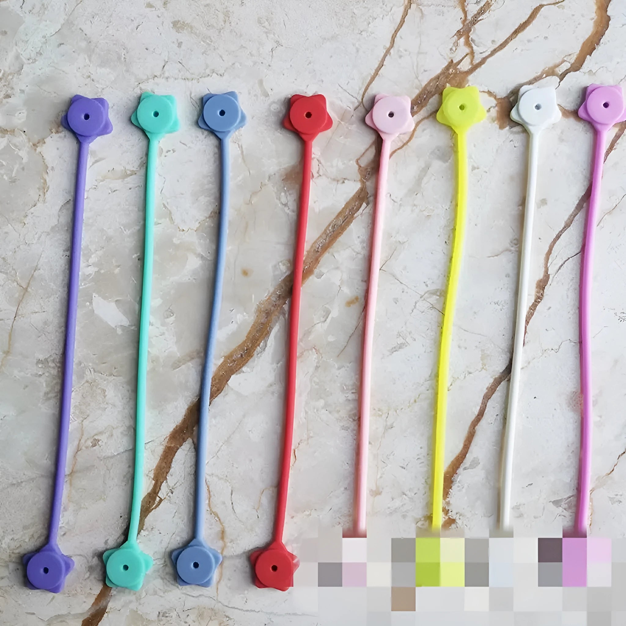 Silicone wire winder with magnet for organising cables in assorted colours on a white background.