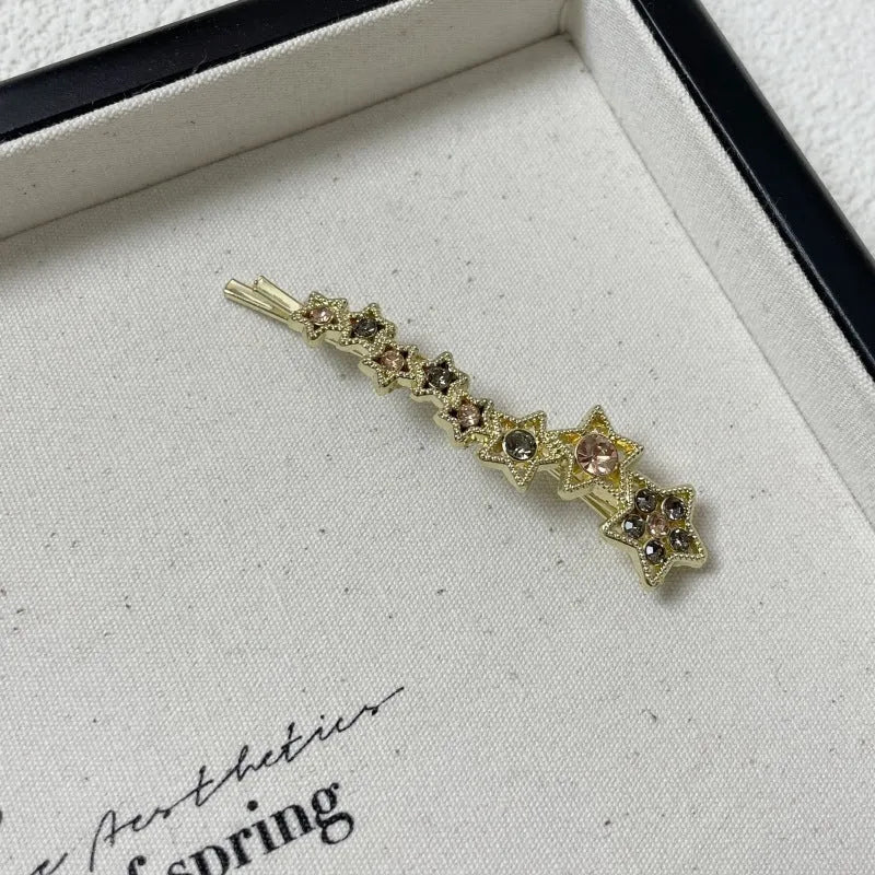 Gold hair barrette clip with rhinestone star detail on side
