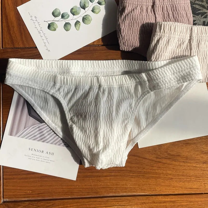 Men's solid colour cotton briefs with mid waist and triangle style in apricot black and skin colour.
