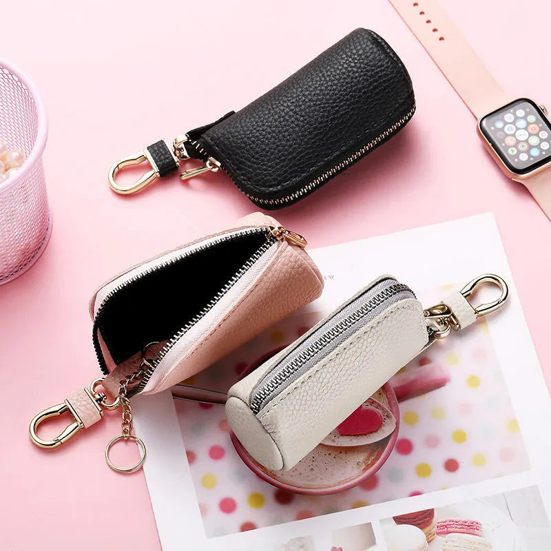 Simple black PU zipper key ring case for car and home keys on a grey background.