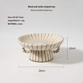 Black and white striped retro-style resin fruit or dessert plate on a table.