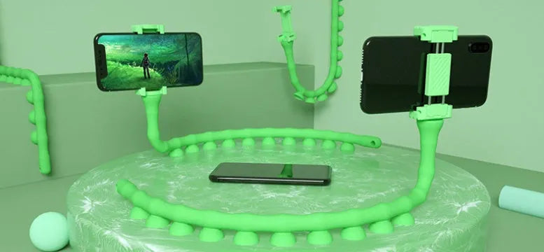 Flexible rubber phone holder with suction cup mounted on desktop showing 360-degree rotation