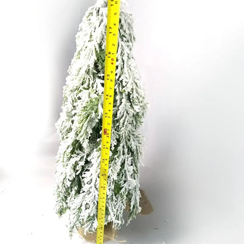 Small 24-inch white artificial Christmas tree with LED lights and snow-covered branches on a desktop.