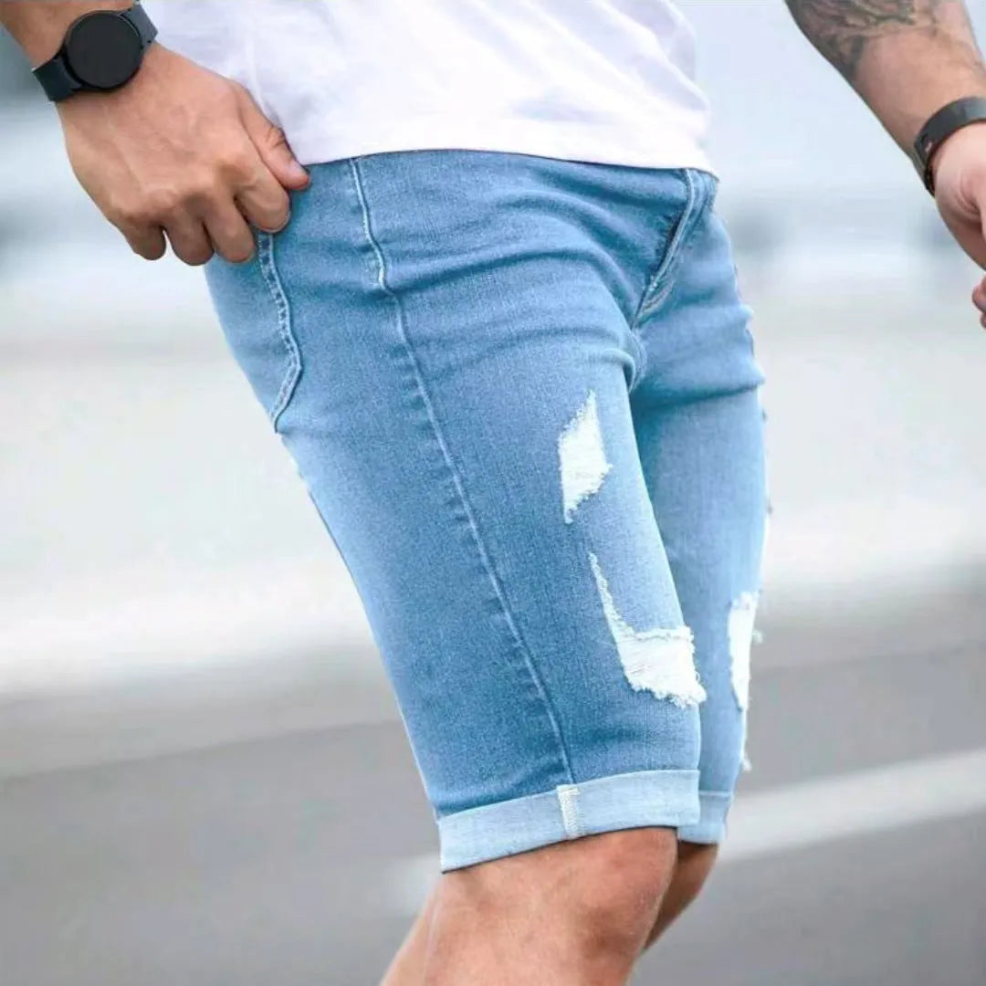 Sky blue denim shorts with multiple distressed holes and straight leg silhouette