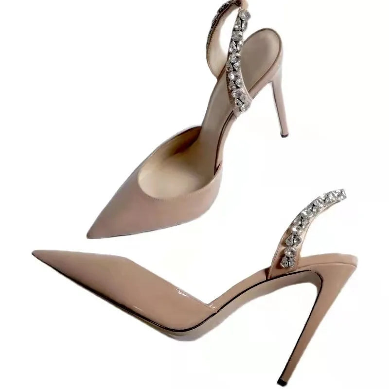Women's black patent leather pointed toe stiletto sandals with rhinestone decorations along the side.