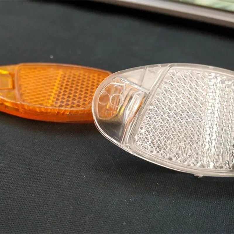 Yellow bicycle wheel reflector with hot wheels design mounted on spoke