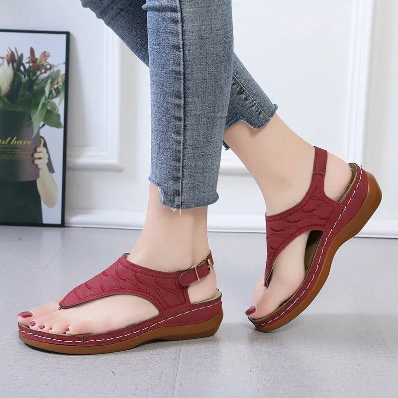 Women's black casual wedge heel flip flop sandals showing adjustable back buckle strap and solid colour design.