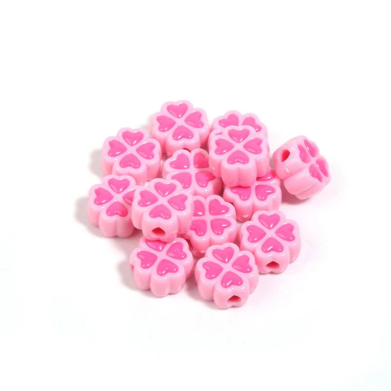 A pile of 15mm frosted acrylic four-leaf clover beads in mixed colours including pink, green, and blue.