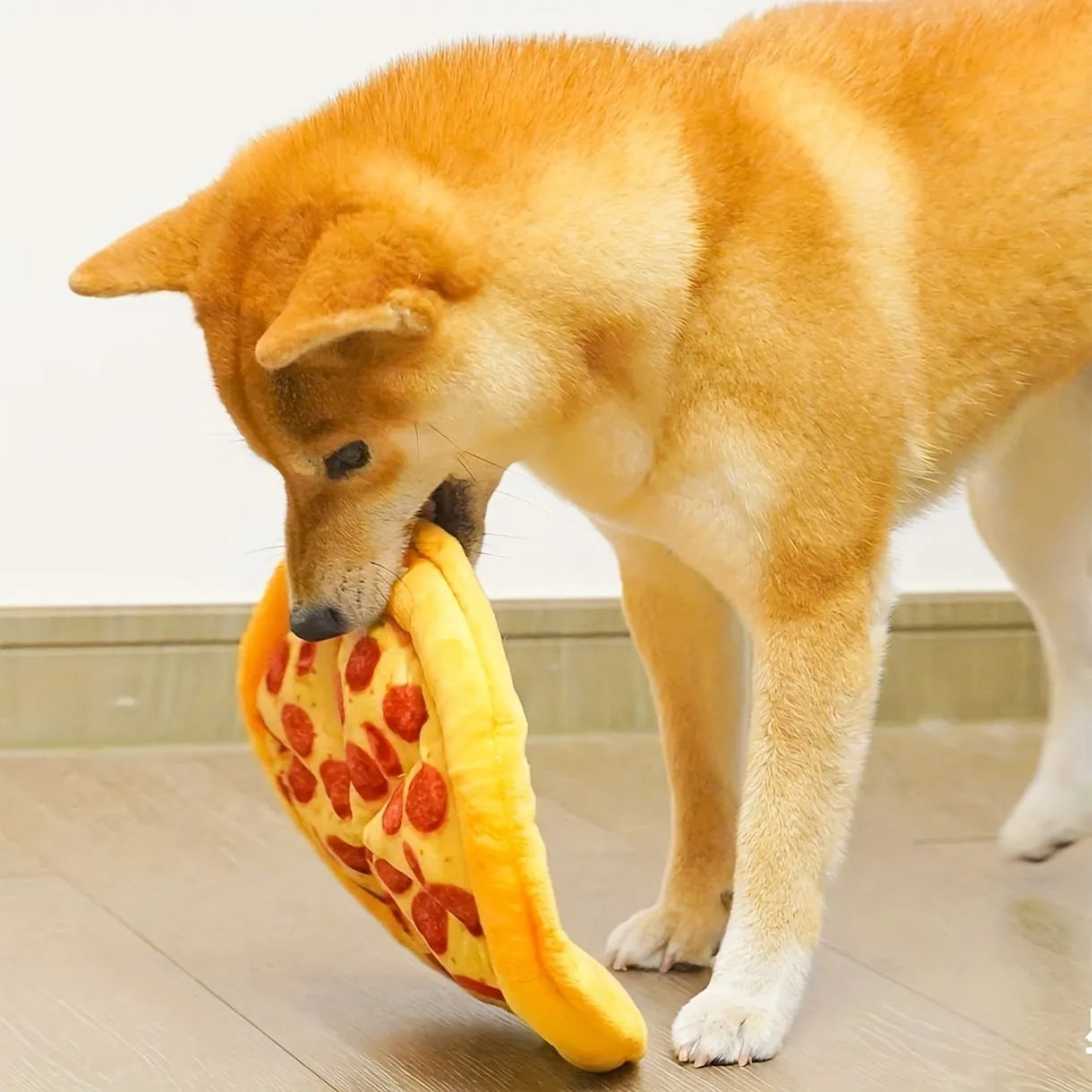 Yellow pizza slice shaped plush dog chewing toy with a squeaker for medium and small dogs.