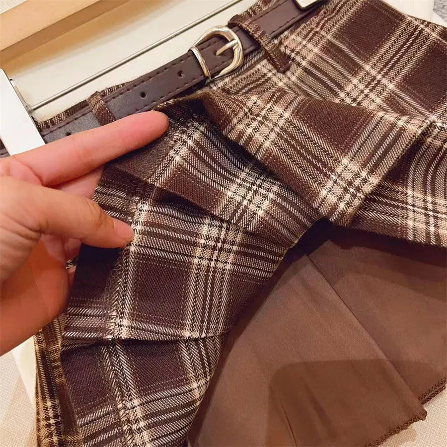 Girls' plaid pleated A-line skirt with an elastic waistband on a hanger.