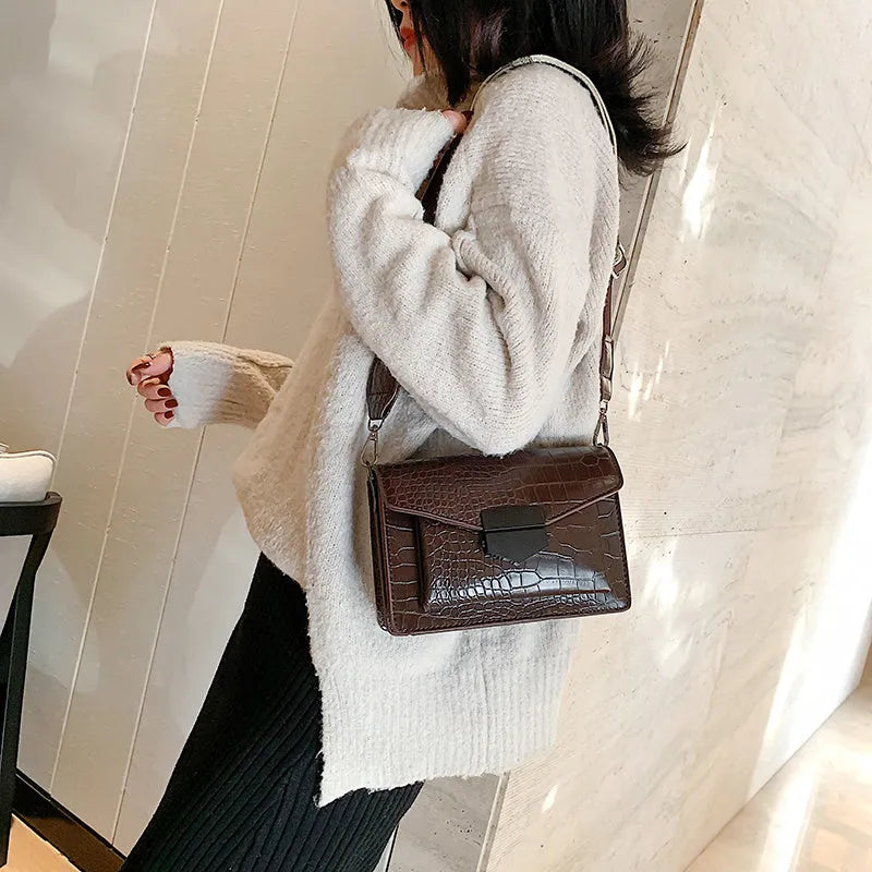 Vintage PU crossbody bag in black, shown with adjustable strap and open to reveal polyester lining.