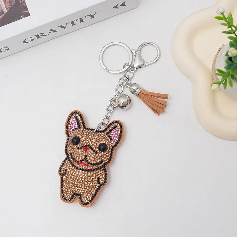 Close-up of a rhinestone dog charm keychain in a caramel colour with sparkling stones on a metal base.