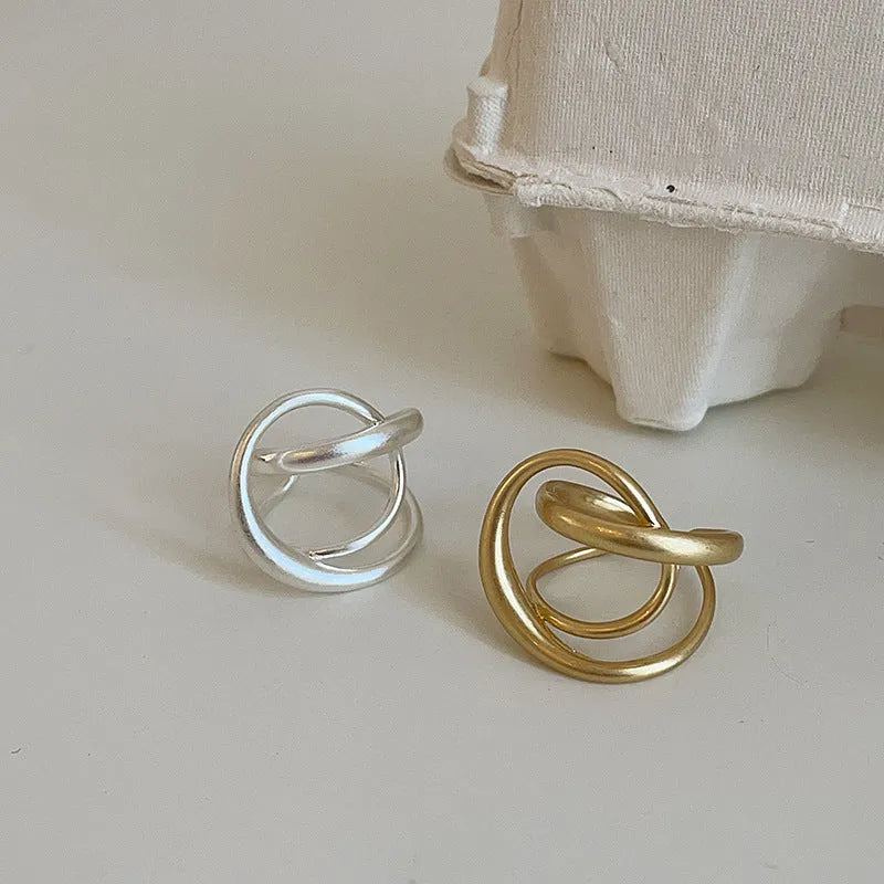 Geometric interlaced matte metal open ring for women in gold or silver.