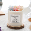 Decorative aromatherapy candle with dried flowers embedded in solid wax, shown with optional wooden chip base.