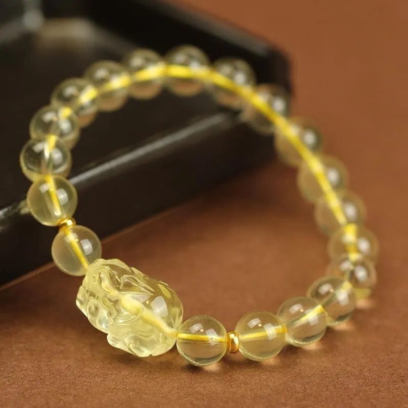 Yellow leather cord bracelet with an artificial citrine crystal Pi Xiu charm and beads.