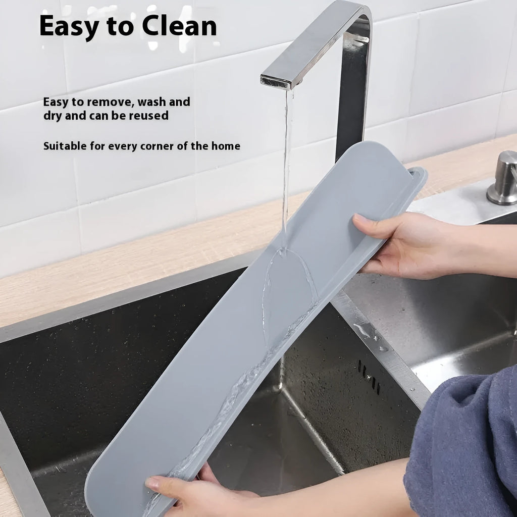 Thick grey silicone kitchen sink water blocking plate sitting on a counter next to a sink