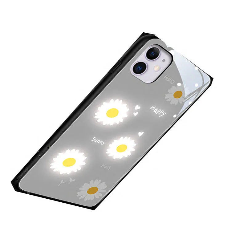 White luminous iPhone case with purple daisy design and voice-activated colour light on a table.