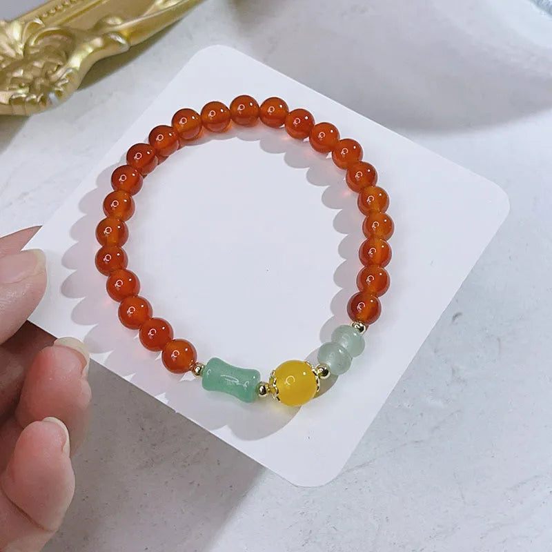 A red agate bracelet for women with Chinese style dragon and lucky bag motifs.