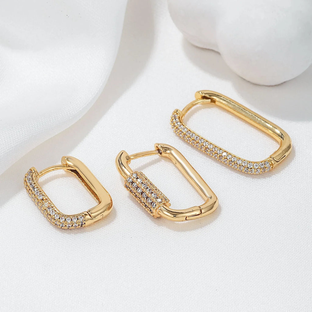 Three geometric copper earrings with zircon micro inlay in clip-on design showing ellipse and quadrilateral shapes
