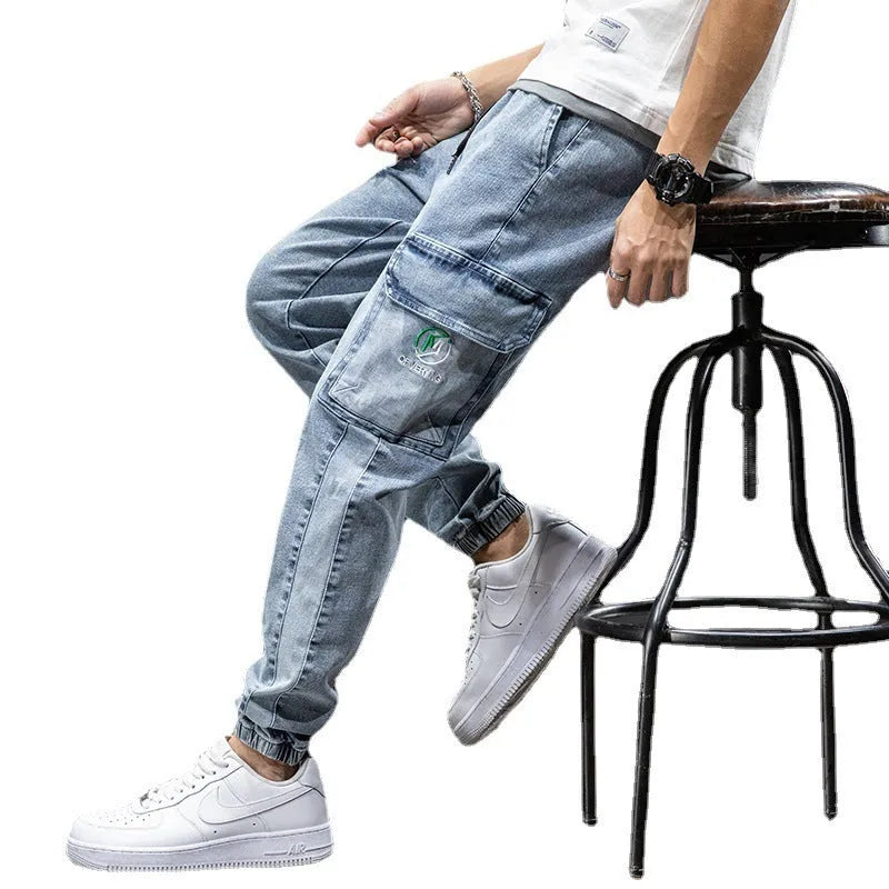 Men's loose-fit light blue cargo jeans with pockets and straight leg on a neutral background.