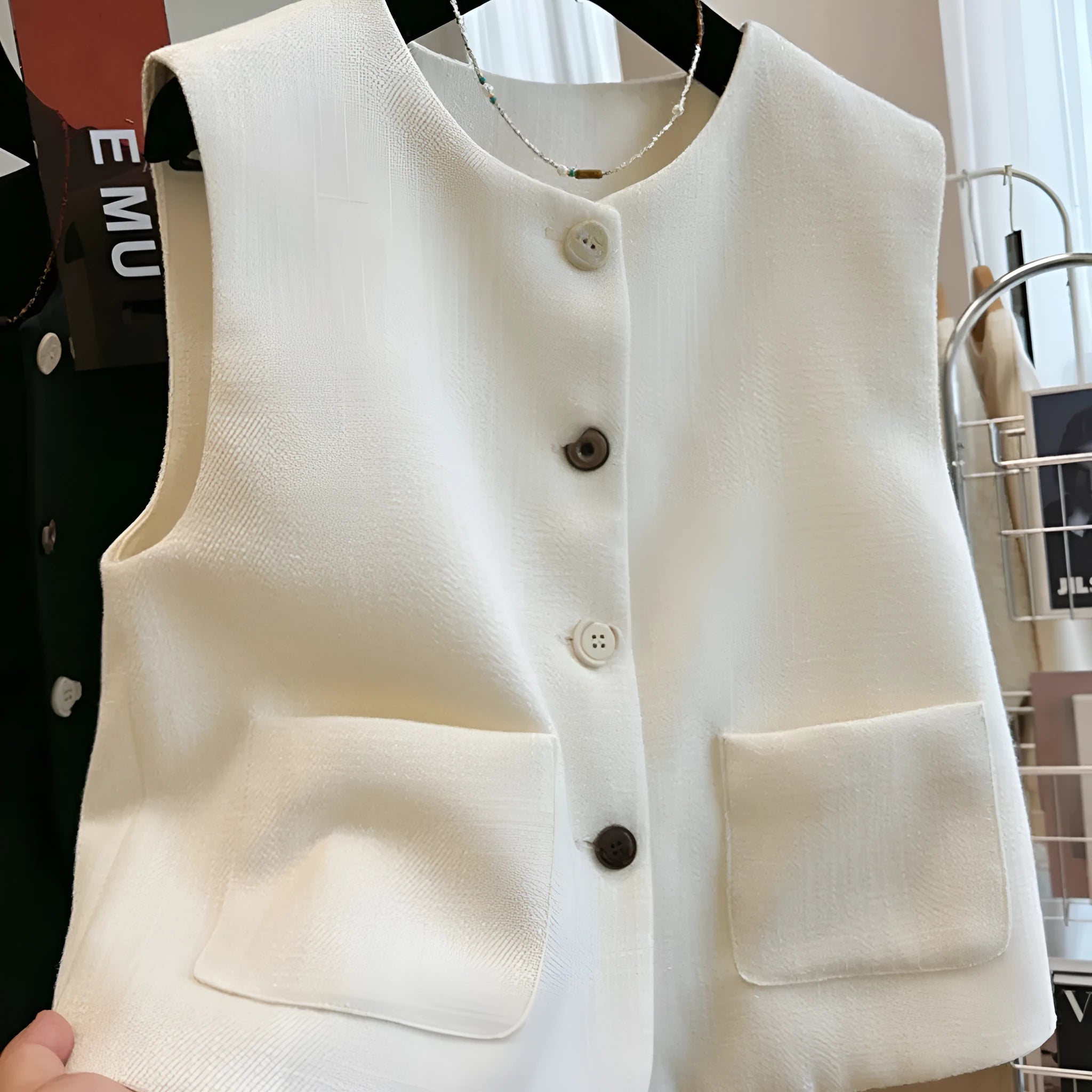 Women's milky white French-style bandage vest with round neck and sleeveless design on a hanger.