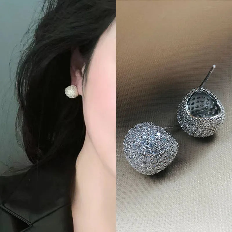 Geometric drop-shaped ear clips with full diamond detailing and sphere elements in gold and white colour options