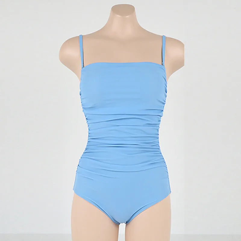 Blue sling style one-piece swimsuit with belly pleating on a mannequin