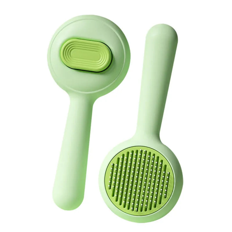 Green and yellow plastic cat brush with stainless steel teeth and a non-slip handle.