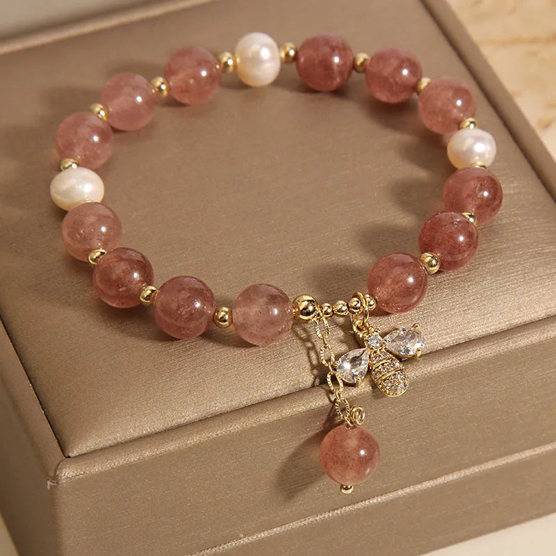 Strawberry quartz and freshwater pearl bracelet with zircon accents on woman's wrist