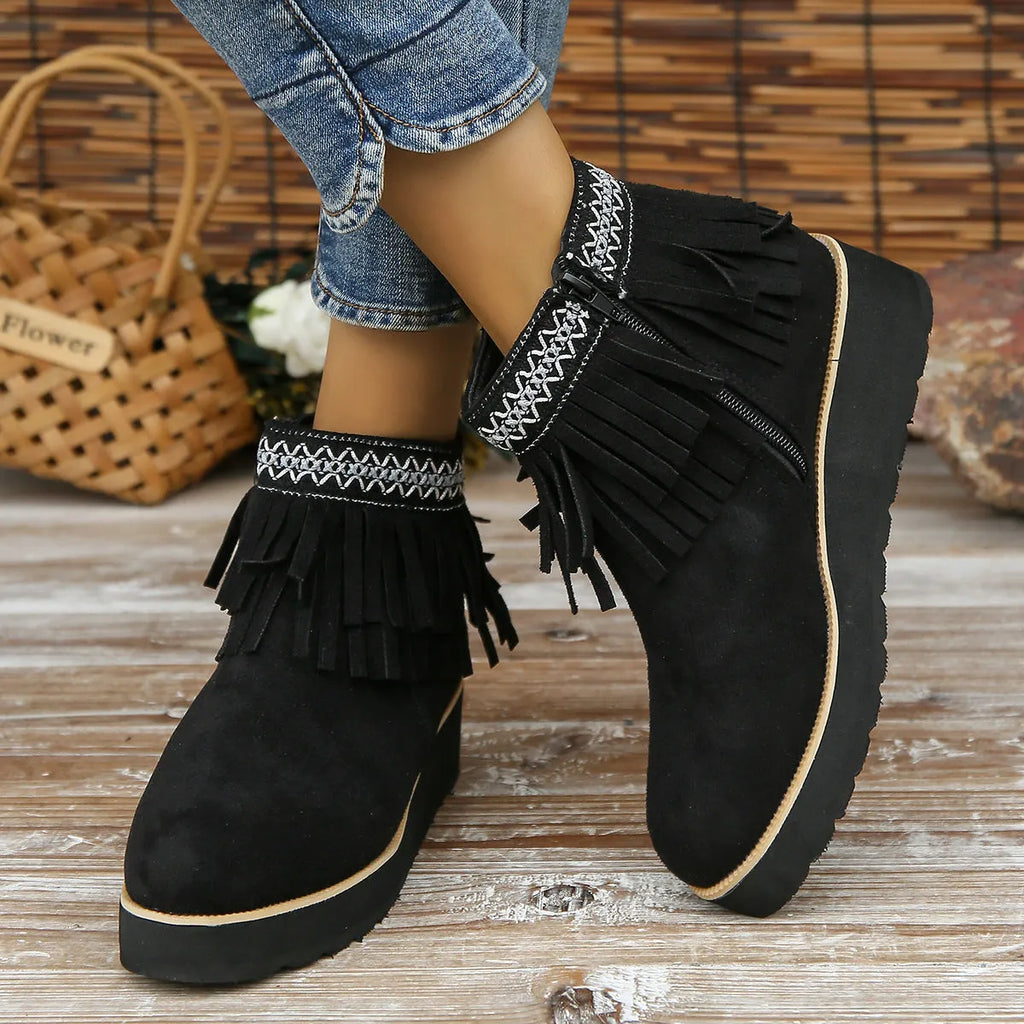 Women's dark brown suede ankle boots with a wedge heel, side zip, and decorative tassel detail.