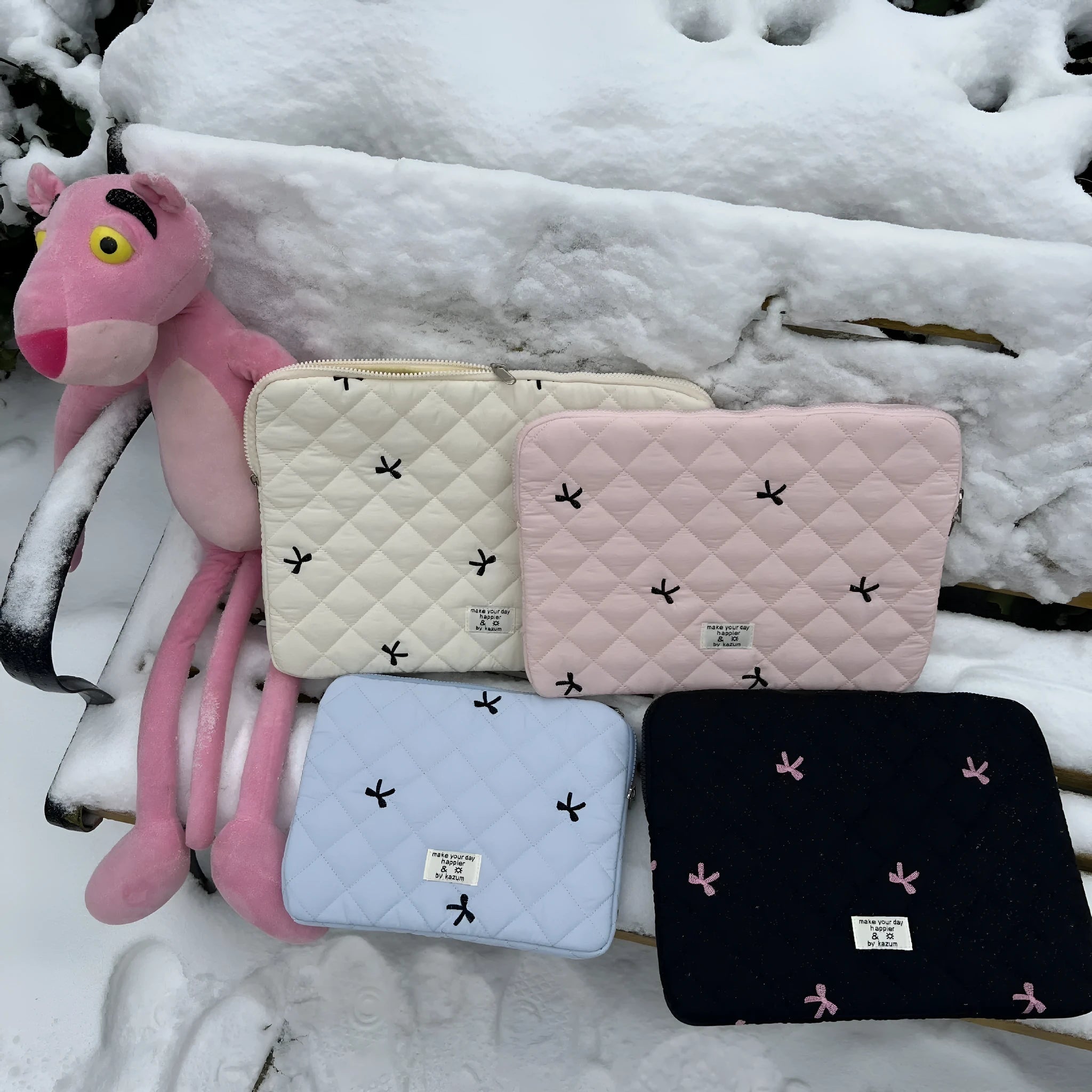 Cute white nylon laptop bag with a rhombus embroidered bow, shown next to a laptop.